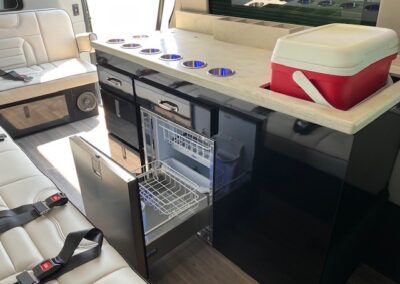 Interior of indulger specialty vehicle showing kitchenette with open dishwasher.