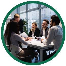 Round image of 5 people meeting around conference table.