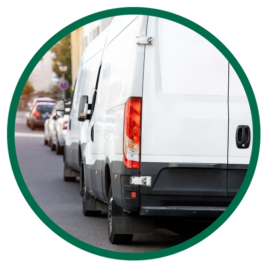 Round image of 2 white specialty vehicles parked on side of road.