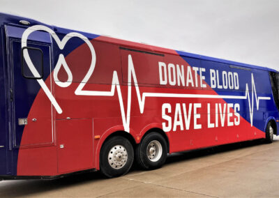 Side view of exterior of mobile blood specialty vehicle that says "Donate Blood Save Lives"