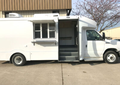 Exterior of white mobile cooking unit.