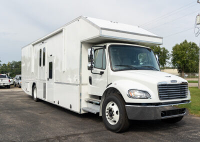 Exterior passenger side image of white specialty trailer.