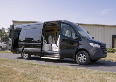 Black Mercedes-Benz TWR personal specialty vehicle parked with doors open so you can see the white interior.