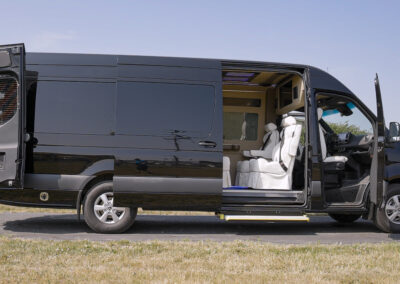 Black TWR Personal specialty vehicle parked with doors open exposing white interior.