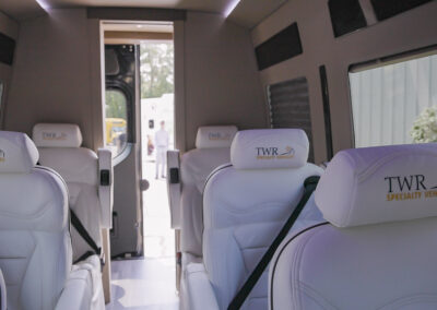 Interior of a TWR Specialty Vehicle showing white seats with TWR Specialty Vehicles on headrest of each seat.