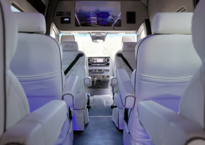 Interior of TWR specialty vehicle with white seats. View from back of vehicle going to the front.