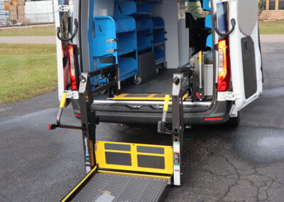 Back end view of a Bookmobile specialty vehicle with back doors open showing lift gate and interior shelves.