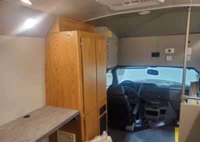 Interior of shelves, cabinets, and front seat of educational mobile classroom specialty vehicle.