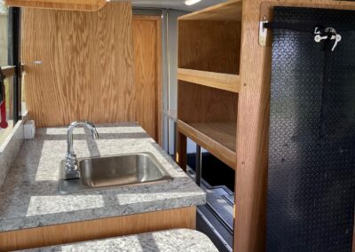 Interior of an Outreach Mobile Meal Dispensing specialty vehicle. View from countertops showing sink and and shelves.