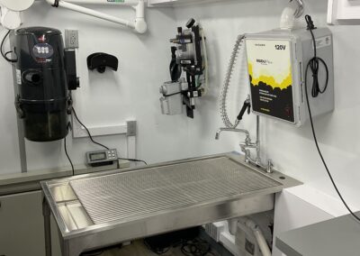 Metal sink with grate and other vet equipment inside of P.A.W.S mobile pet services vehicle