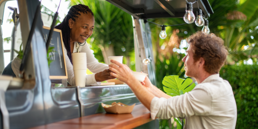 a women giving a coffee to her customer from a mobile business