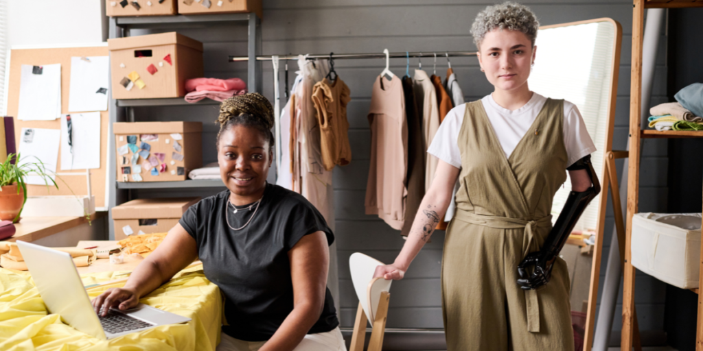 Two young successful female tailors or fashion designers in a mobile business vehicle