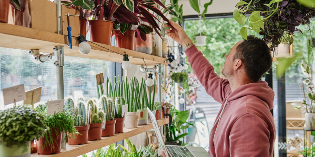 a man in a mobile plant shop looking at a plant