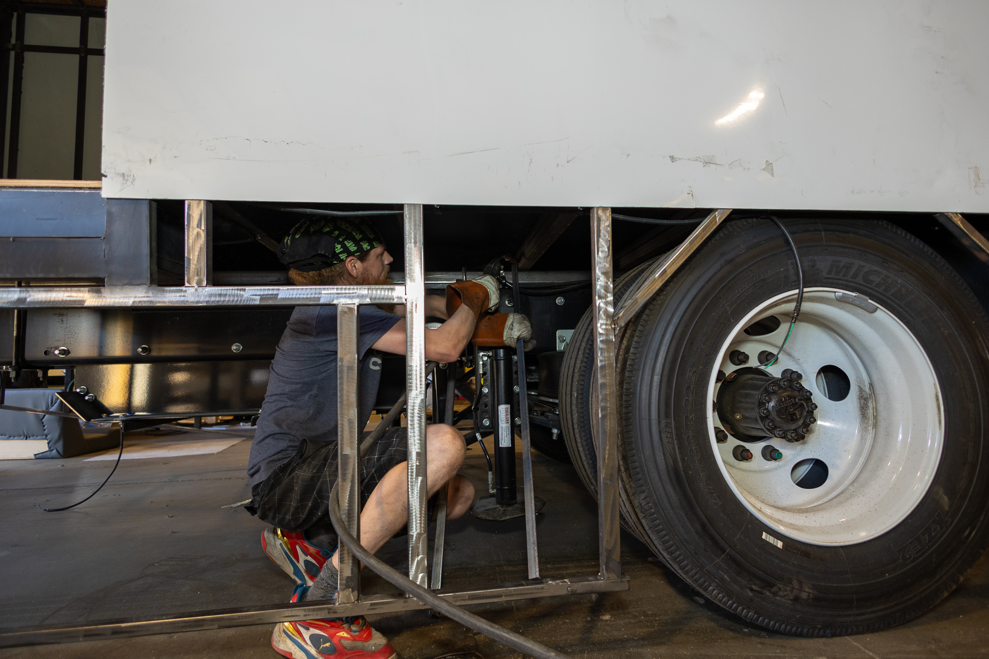 Round image with green circle on outside showing person fabricating materials.